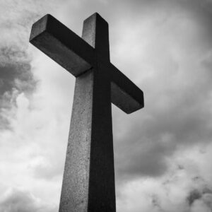 low angle photo of concrete cross under clouds